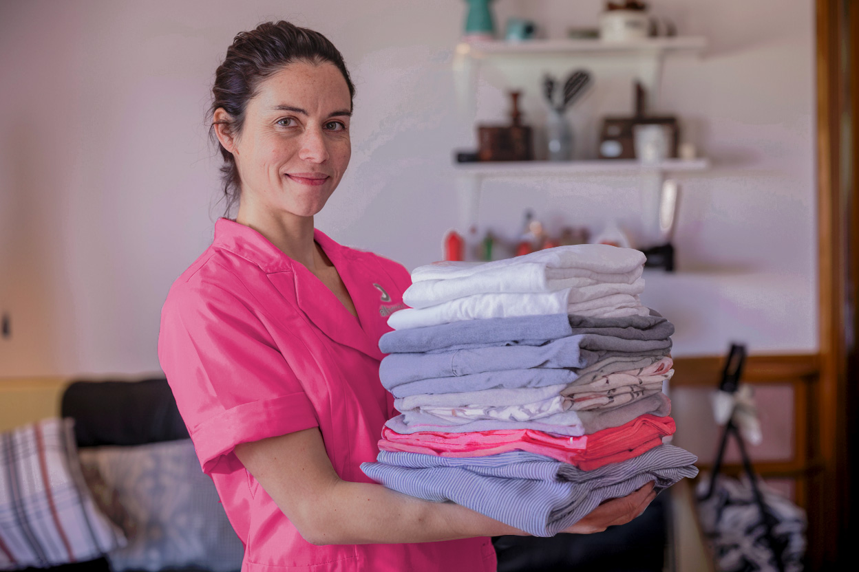 Carer holding a pile of folded laundry