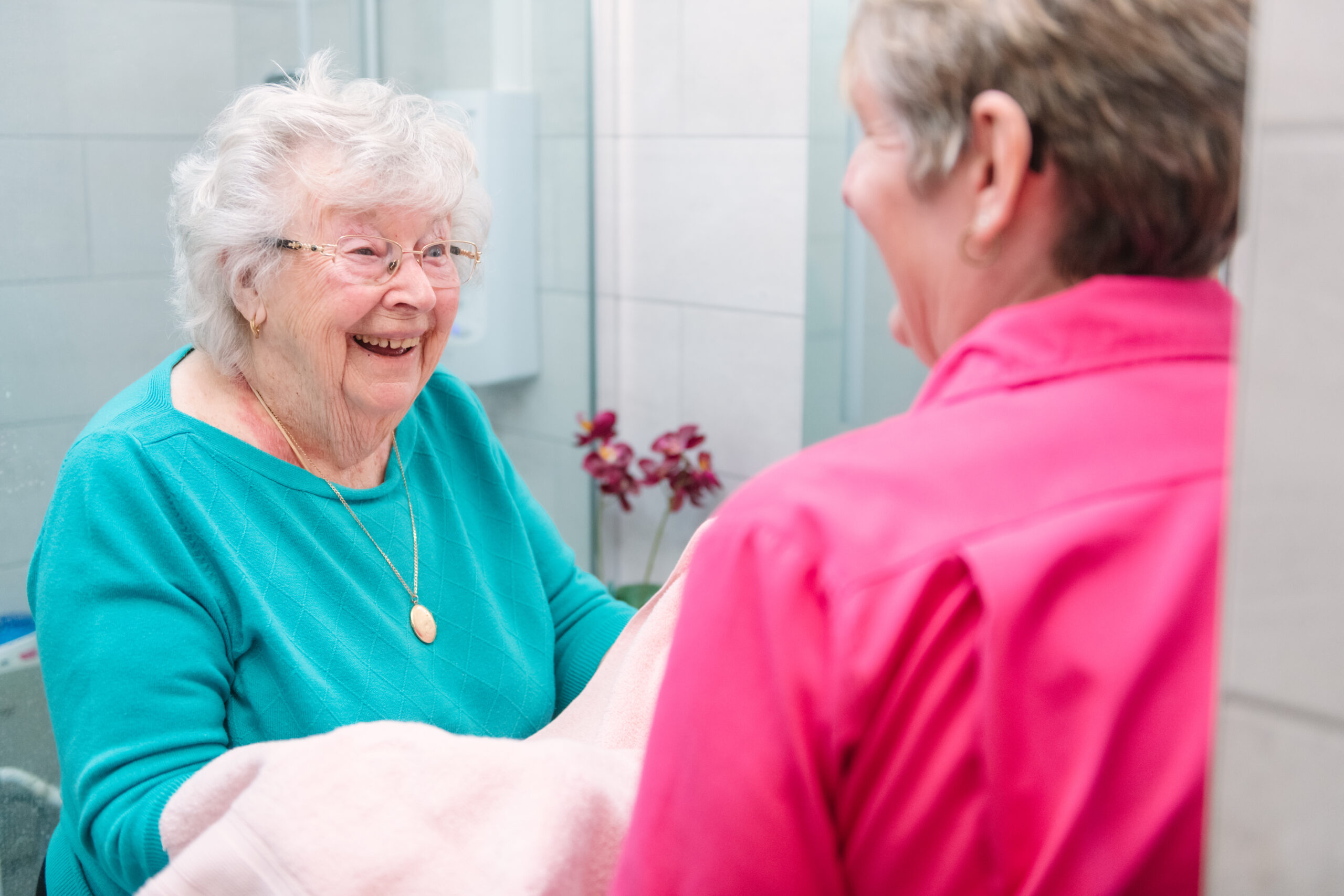 Carer helping elderly client with personal hygiene