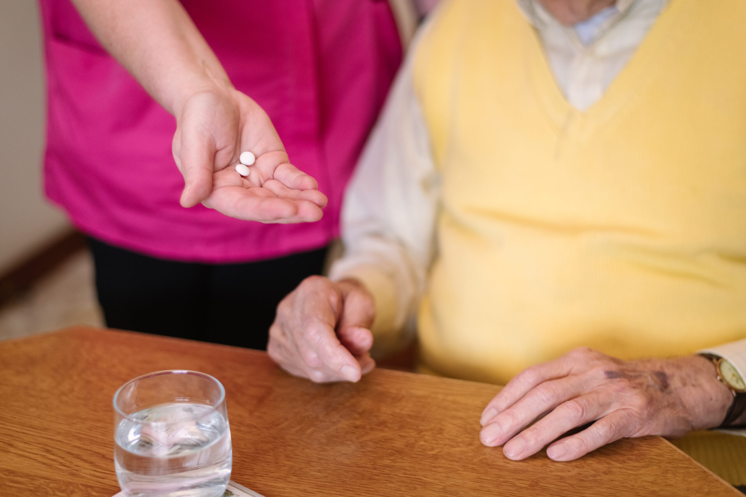 Carer assisting with elderly client's medication